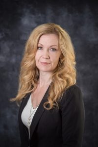 Leonarda Decker is a middle-aged woman with blonde hair and wearing a black blazer.